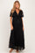 woman wearing a black lace maxi maternity dress with a tie front and short sleeves, showing her baby bump