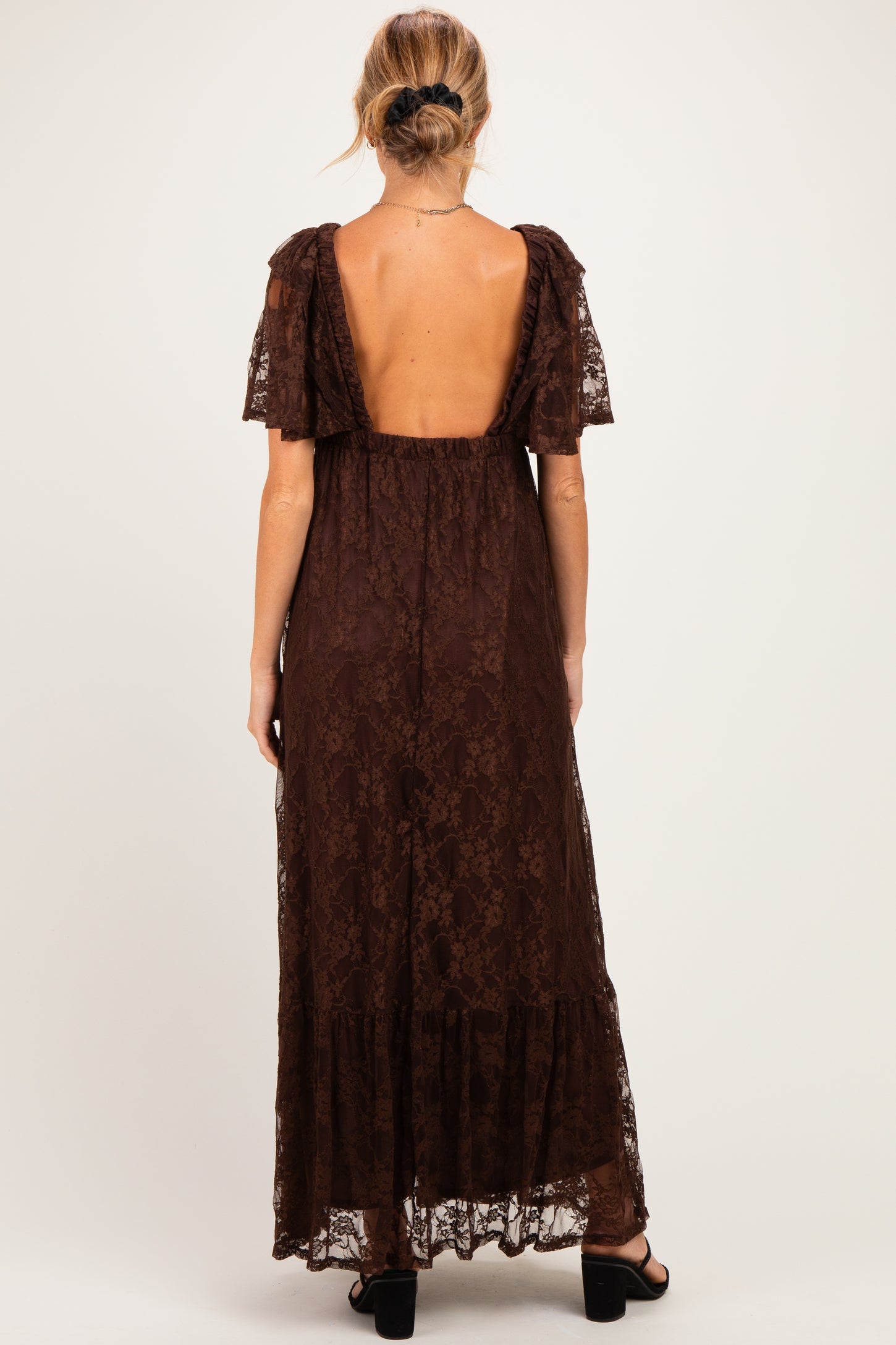 woman wearing a brown lace maternity maxi dress with short puff sleeves and a low back