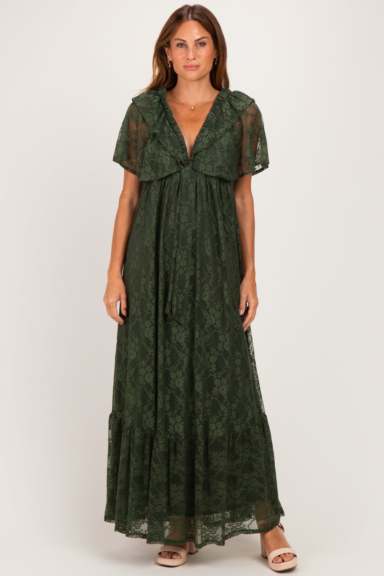woman wearing a dark green lace maxi dress with flutter sleeves and a tie front detail