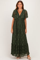 woman wearing a dark green lace maxi dress with flutter sleeves and a tie front detail