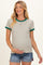 woman wearing a striped maternity top with green ringer sleeves and a baby bump visible, paired with shorts