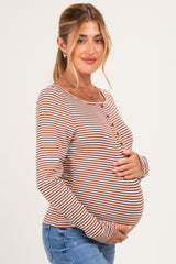 woman wearing a striped maternity long sleeve top and holding her baby bump