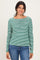 woman wearing a green and white striped long sleeve henley top with buttons and blue jeans