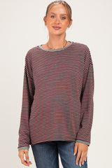 woman wearing a maroon and cream striped maternity top with long sleeves and a relaxed fit