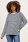 woman wearing a black and white striped long sleeve maternity top with a relaxed fit and a smile