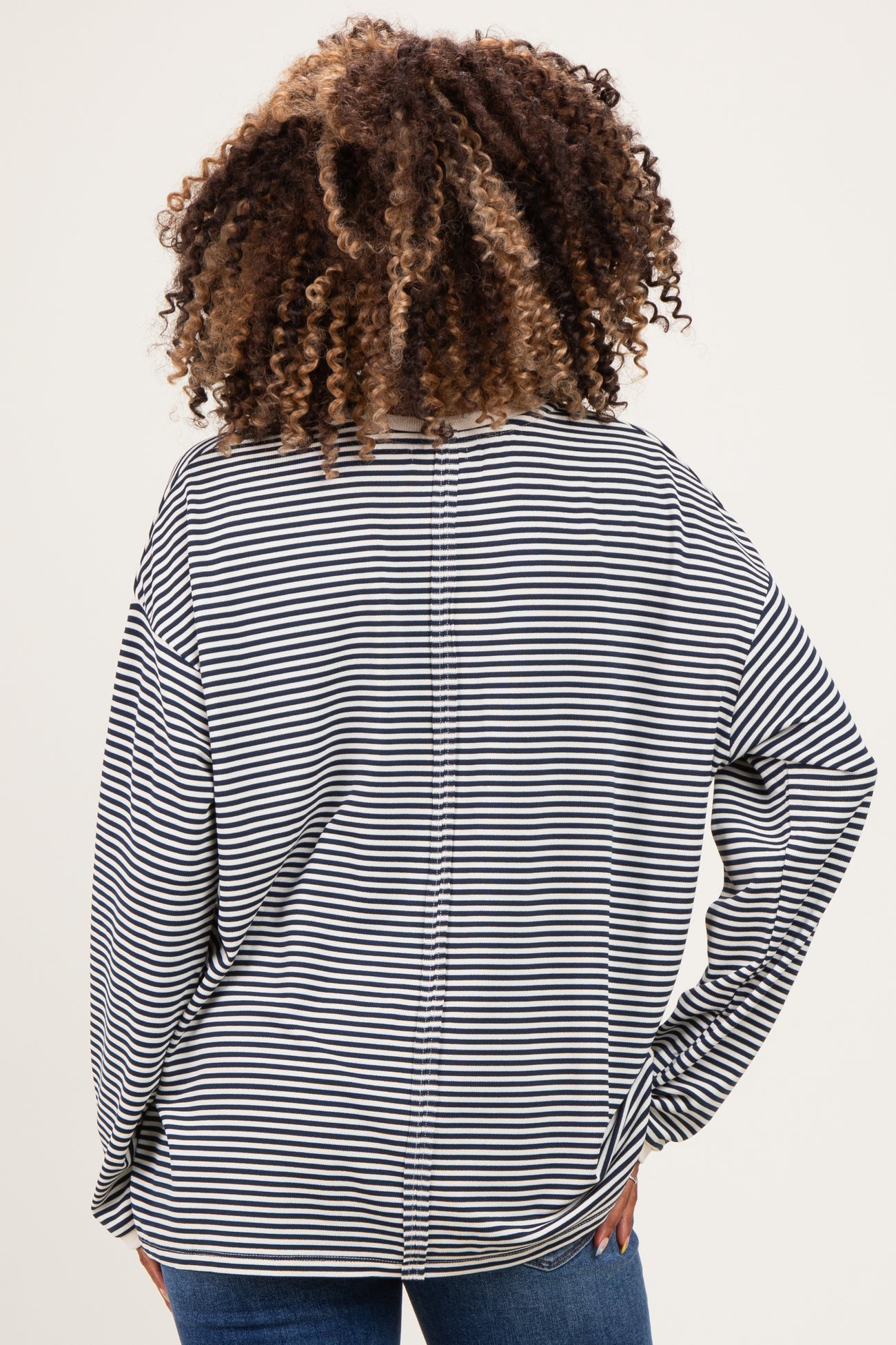 woman wearing a black and white striped maternity top, showing the back view with loose fit and wide sleeves