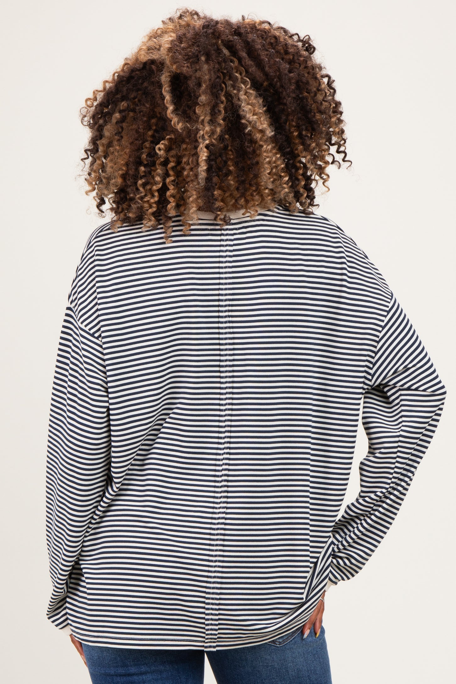 woman wearing a black and white striped maternity top, showing the back view with loose fit and wide sleeves