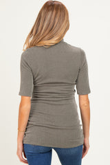woman wearing a dark green ribbed maternity top with short sleeves, view from the back
