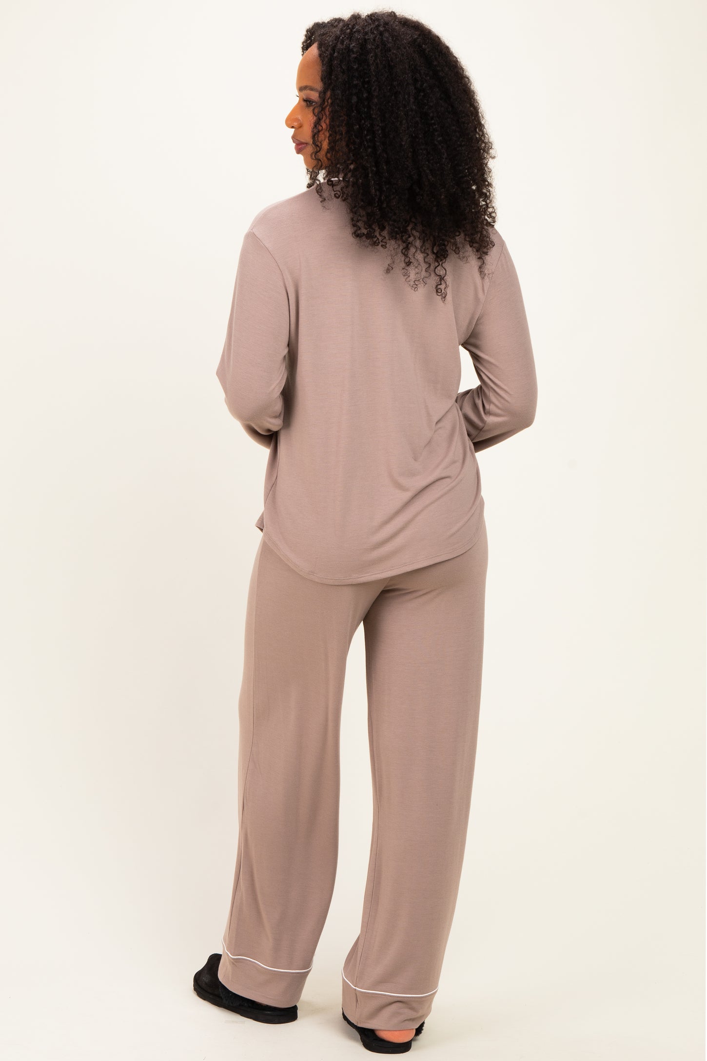 woman wearing a taupe long sleeve loungewear top and matching wide-leg pants, seen from the back