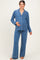 woman wearing a blue maternity pajama set with white piping and a visible baby bump