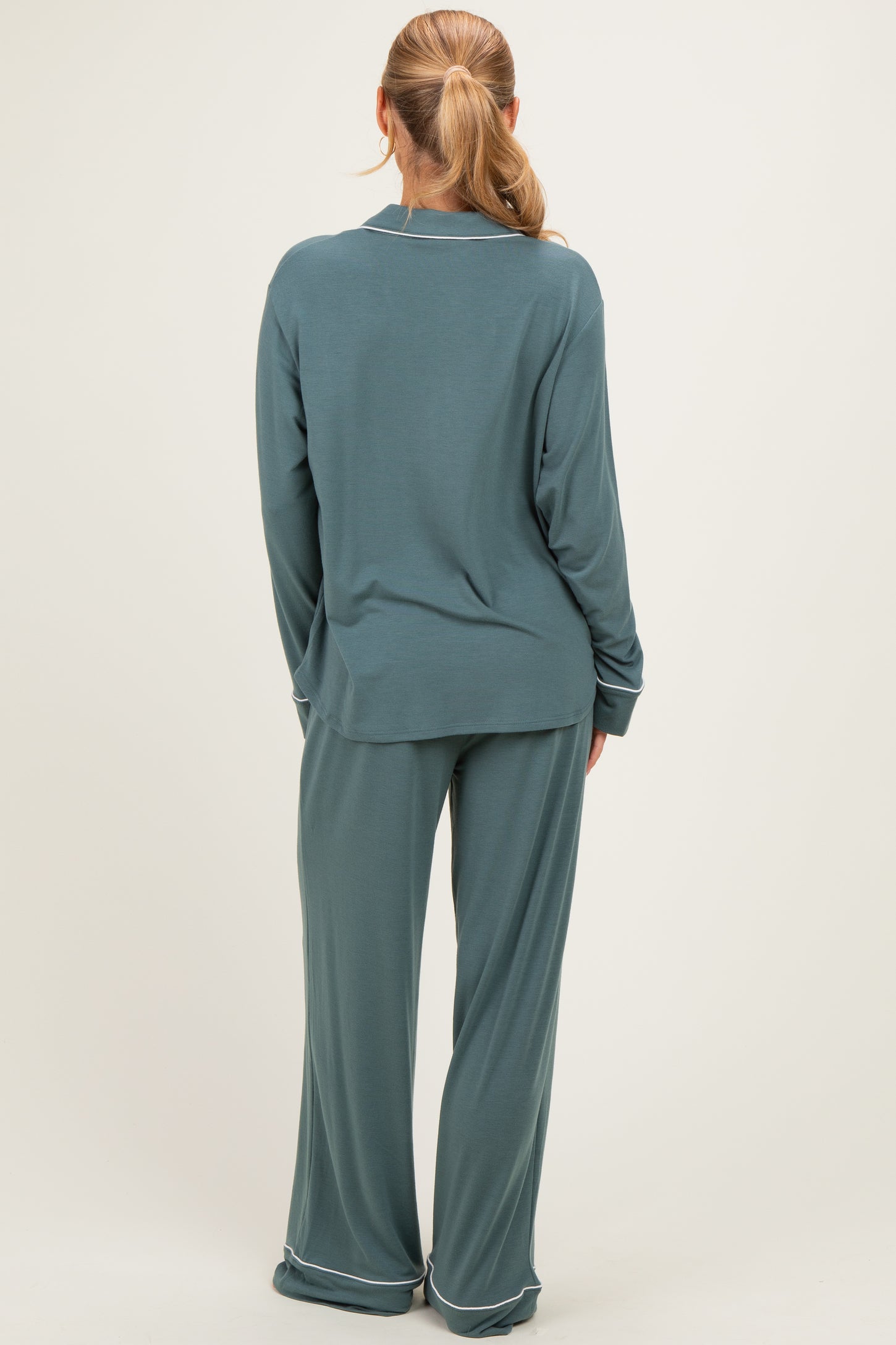 woman wearing a teal long sleeve top and matching wide-leg pants, viewed from the back