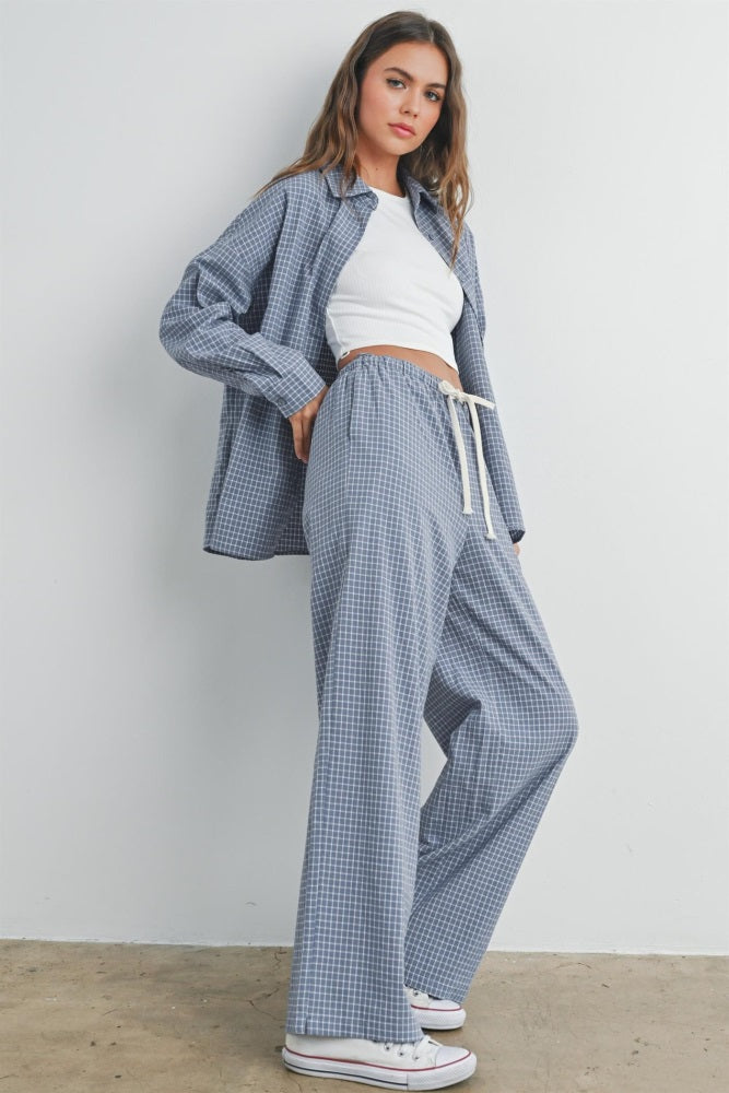 woman wearing a blue and white gingham check oversized shirt with matching pants and a white crop top