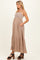 woman wearing a beige maternity maxi dress with a smocked bodice and pockets, showing her baby bump