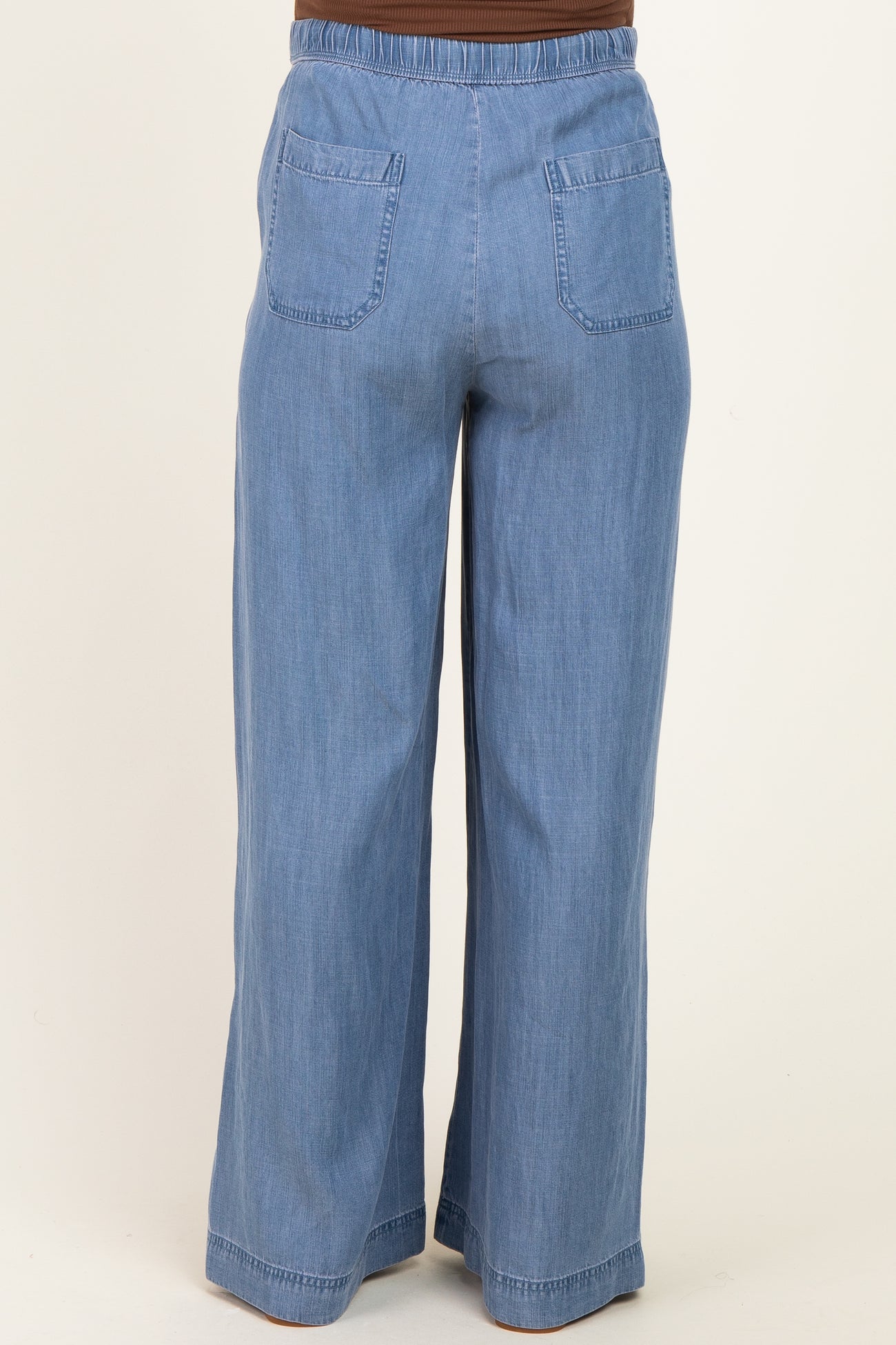 maternity wear light blue wide leg pants with an elastic waistband and back pockets, shown from the back