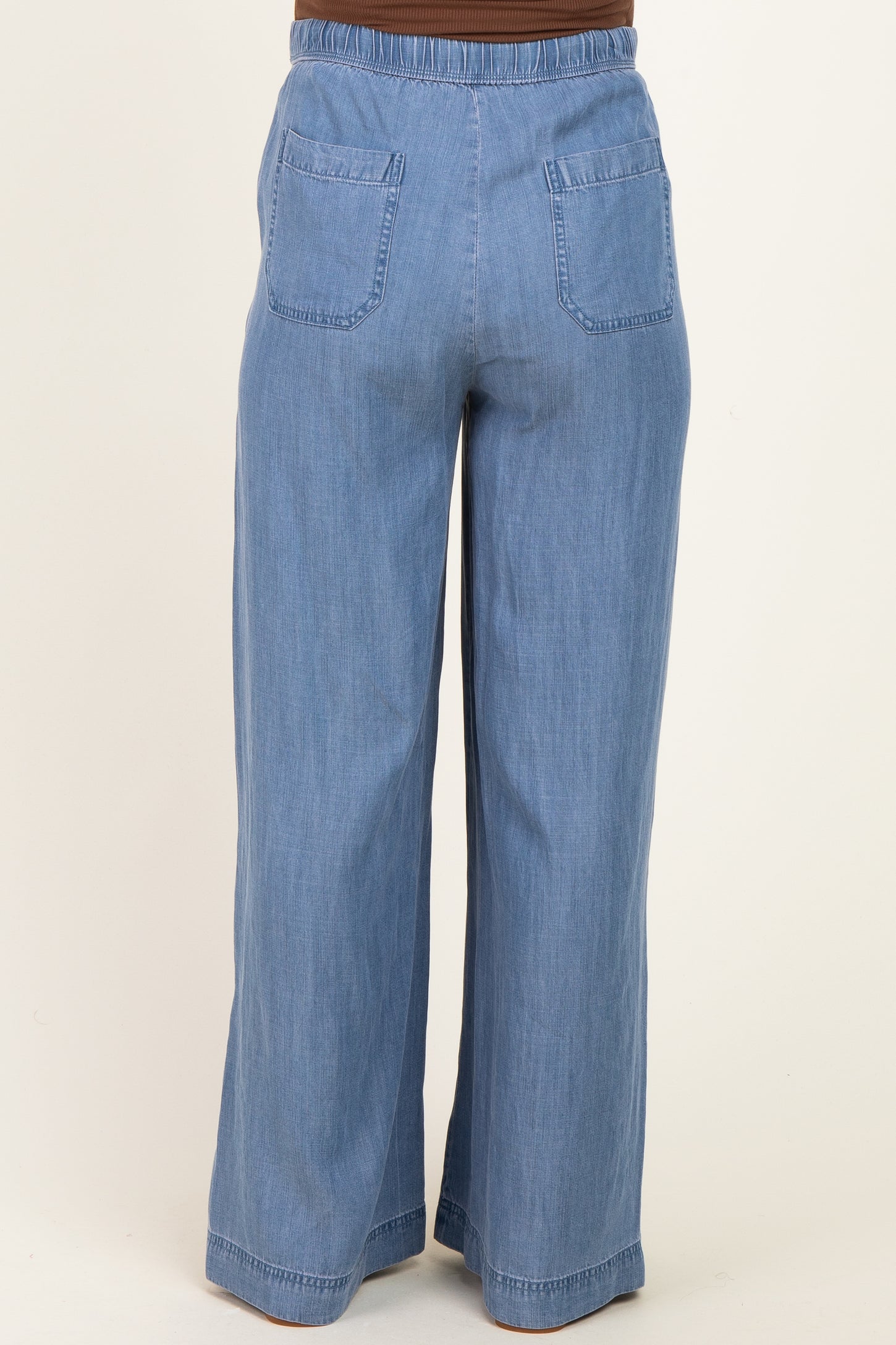 maternity wear light blue wide leg pants with an elastic waistband and back pockets, shown from the back