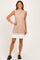 woman wearing a beige ribbed sleeveless dress with a pleated white hem and black chunky shoes