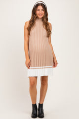 woman wearing a beige ribbed maternity dress with a white hem and black ankle boots