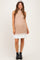 woman wearing a beige ribbed maternity dress with a white hem and black ankle boots