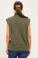 woman wearing a green sleeveless maternity sweater with a mock neck and back view, paired with blue jeans