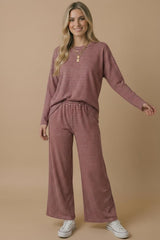 woman wearing a pink and white striped loungewear set with a relaxed fit top and wide-leg pants