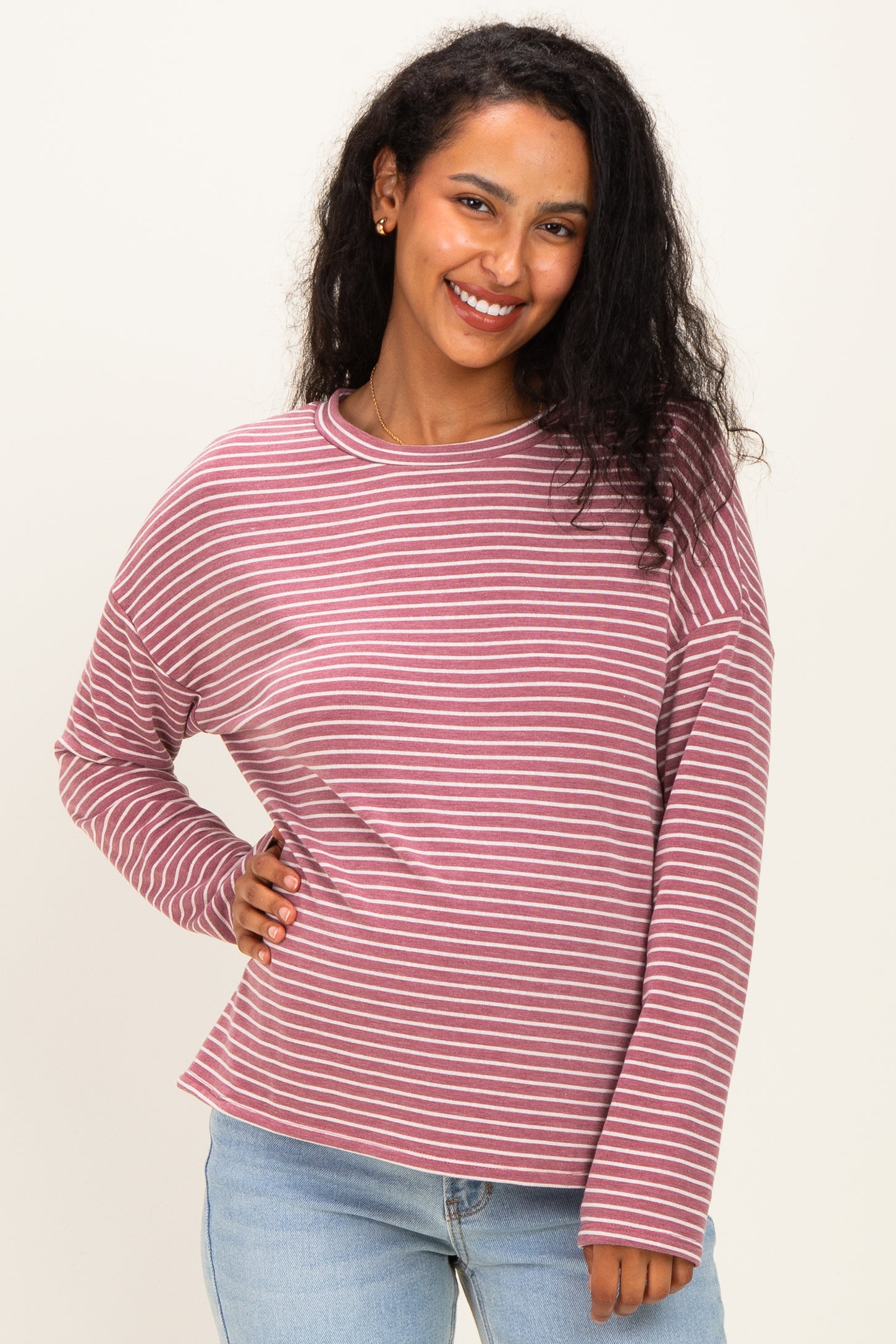 woman wearing a mauve striped maternity top with long sleeves and a relaxed fit