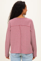 woman wearing a burgundy and white striped maternity top, shown from the back