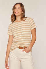 woman wearing a cream and beige striped short sleeve t-shirt with a relaxed fit and styled with light pants