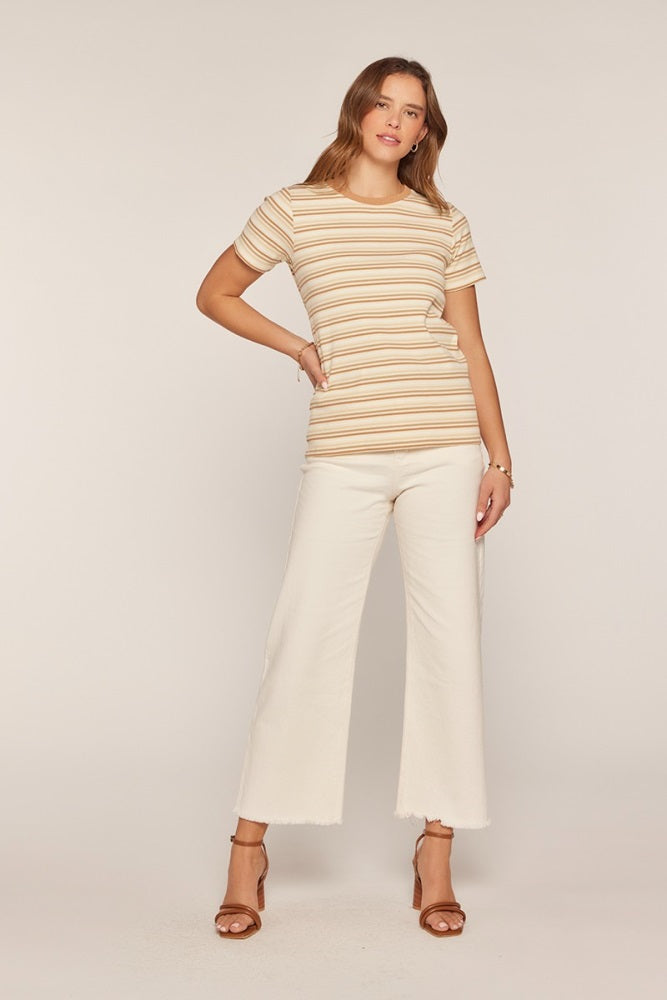 woman wearing a beige and cream striped short sleeve top with white wide-leg jeans and brown heeled sandals