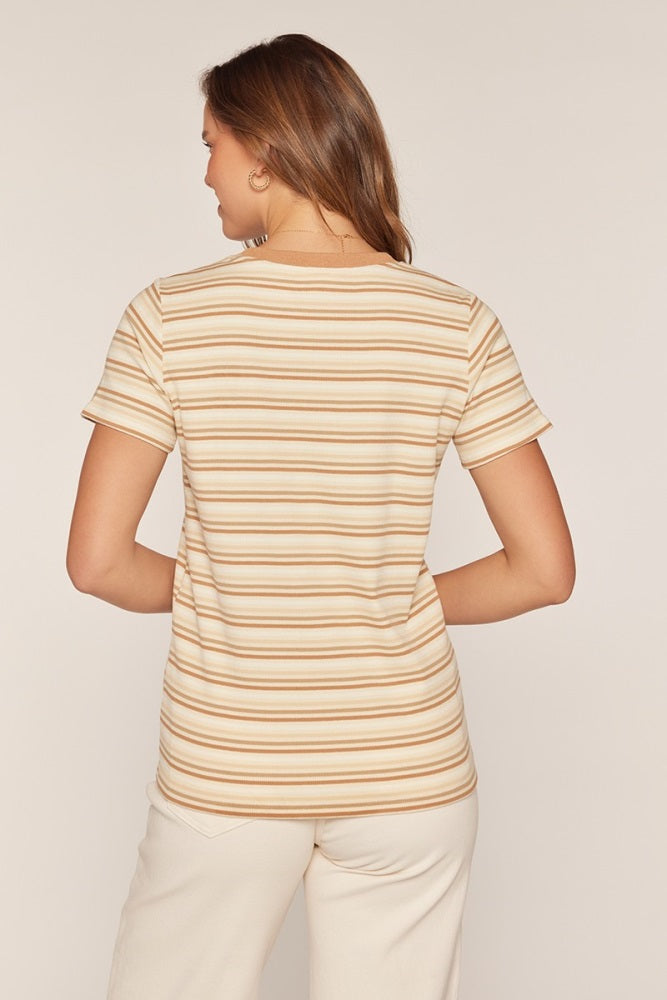 woman wearing a striped short sleeve top in beige and orange tones, viewed from the back