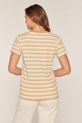 woman wearing a striped short sleeve top in beige and orange tones, viewed from the back
