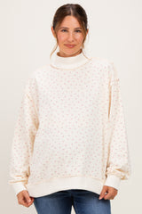 woman wearing a cream floral print maternity sweatshirt with a high collar and relaxed fit