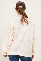 woman wearing a cream maternity sweatshirt with a floral design, featuring a high neck and oversized fit, viewed from the back