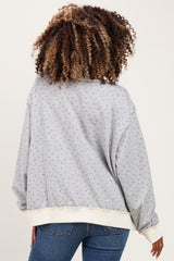 woman wearing a gray maternity sweatshirt with a floral pattern and relaxed fit, styled with blue jeans