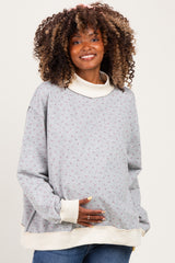 woman wearing a gray floral print maternity sweatshirt with a cowl neck and visible baby bump