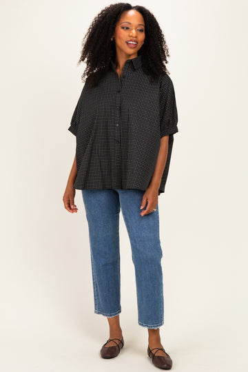 woman wearing a black and white checkered oversized button-up shirt with denim straight-leg jeans