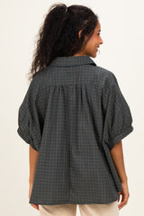 woman wearing a dark green checkered maternity shirt with puff sleeves and a relaxed fit, showing the back view