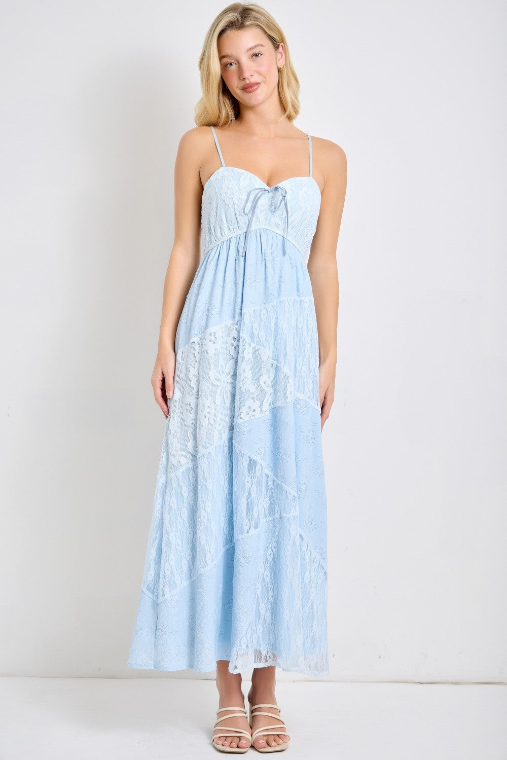 woman wearing a light blue maxi dress with lace details and adjustable spaghetti straps