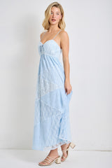 woman wearing a light blue maxi dress with lace detailing and spaghetti straps, styled with heeled sandals