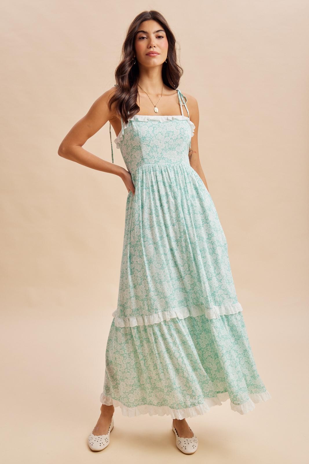 woman wearing a teal floral maxi dress with ruffled straps and a tiered skirt, styled with white flats