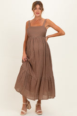 woman wearing a brown polka dot maternity dress with a square neckline and ruffled hem, showcasing her baby bump