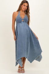 woman wearing a denim blue maternity dress with a smocked bodice and an asymmetrical hem, showing her baby bump