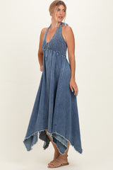 woman wearing a denim blue halter maxi dress with a smocked bodice and raw hem details