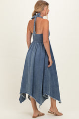 woman wearing a backless denim maxi dress with a halter neck and a frayed hemline, styled for summer