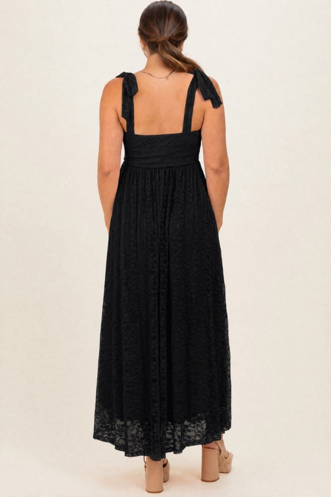 woman wearing a black lace maternity maxi dress with tie straps, showing a stylish back view