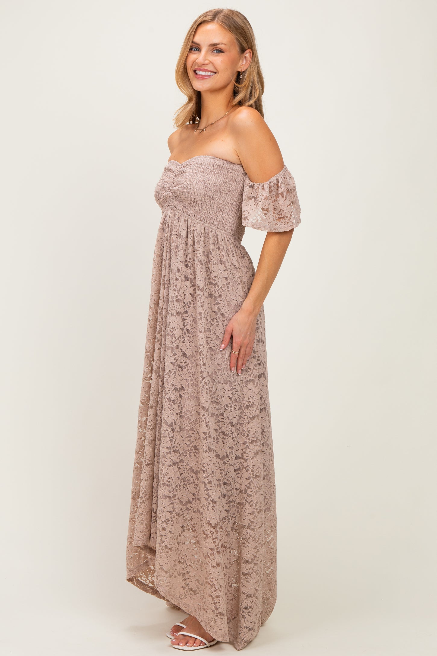 woman wearing a blush off-the-shoulder maxi dress with a smocked bodice and puff sleeves