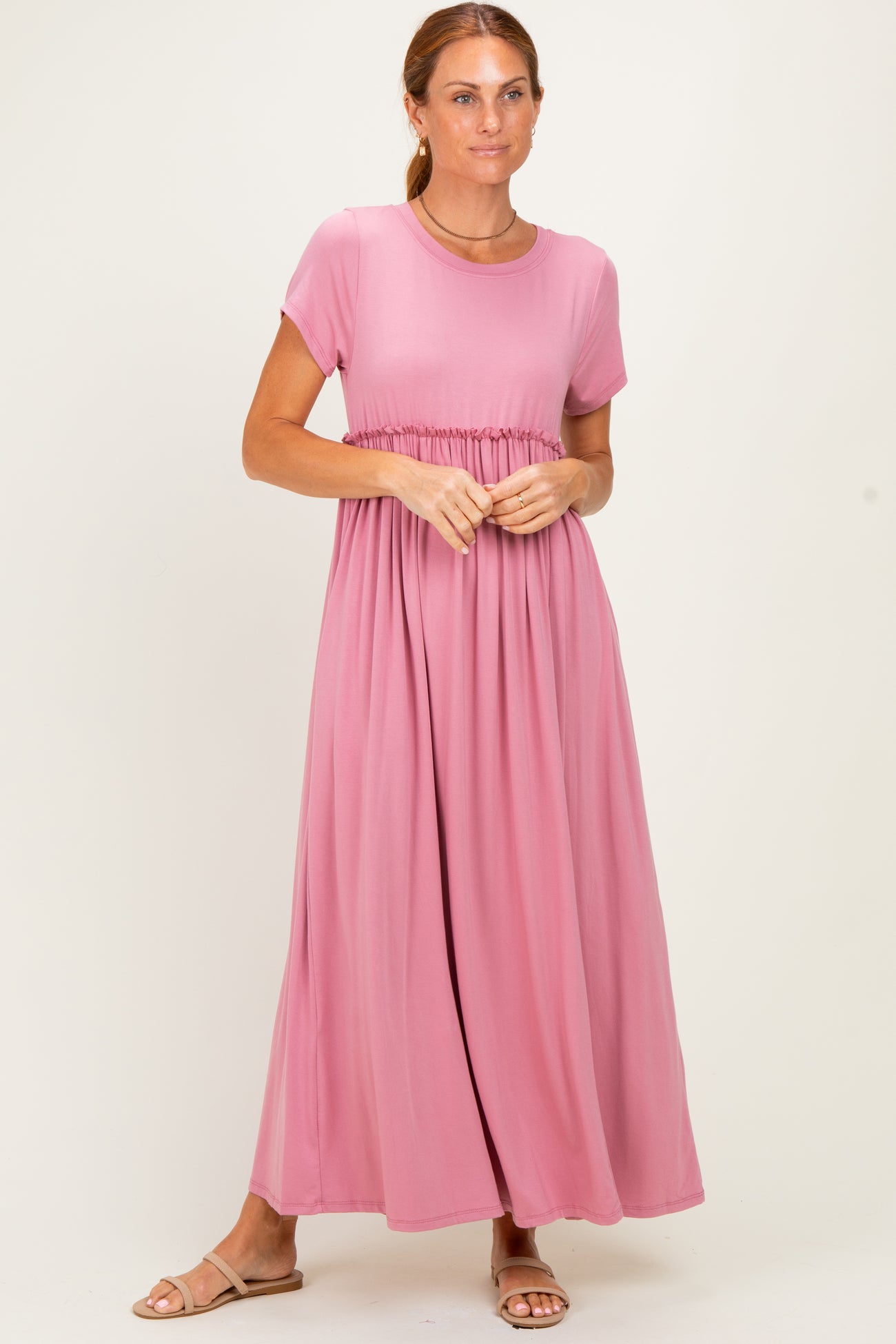 woman wearing a pink short sleeve maxi dress with a smocked waist and flowy skirt