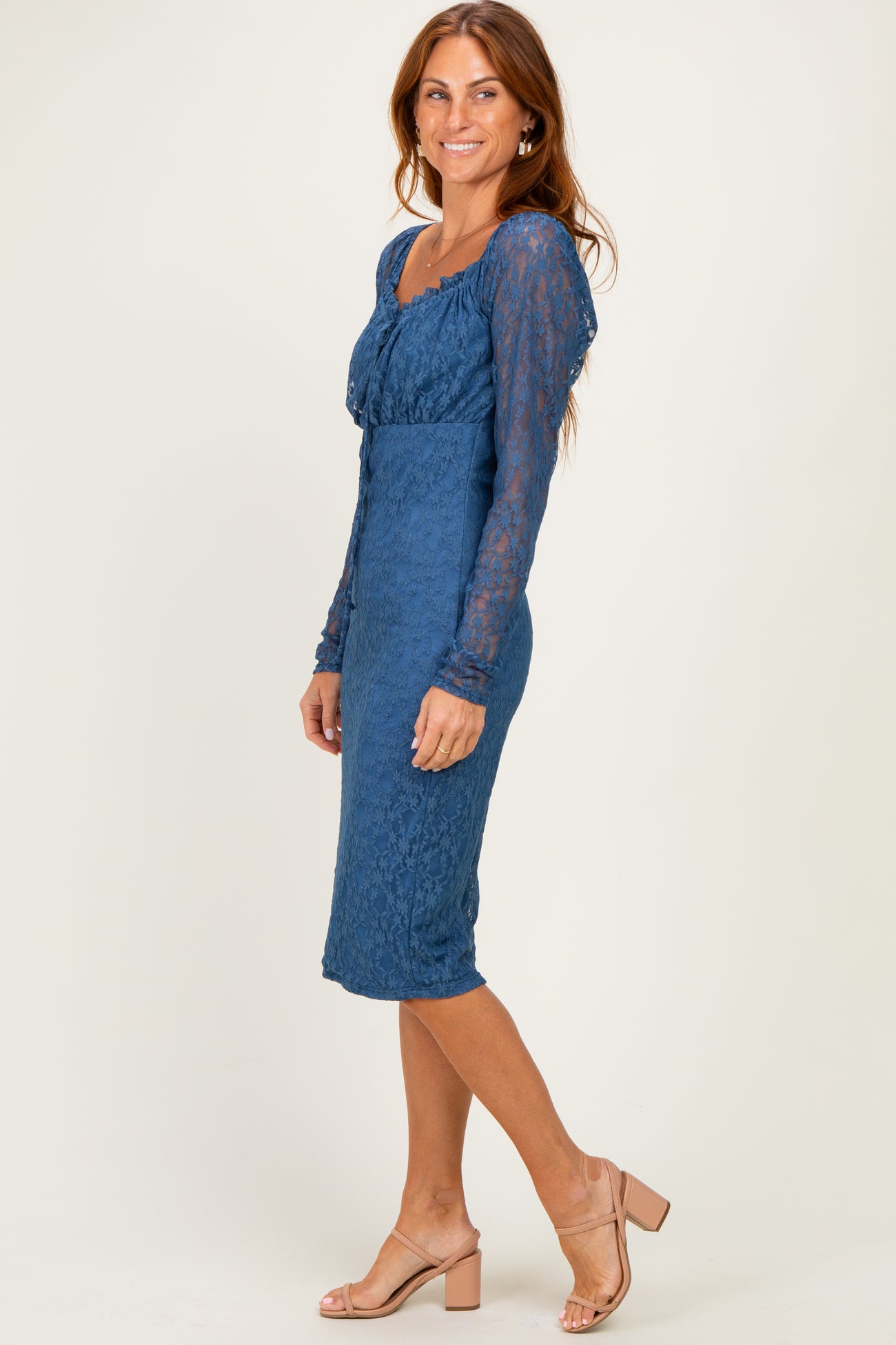 woman wearing a blue lace long sleeve midi dress with a fitted silhouette and a scoop neckline