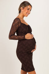 woman wearing a brown lace maternity dress with long sleeves and a visible baby bump