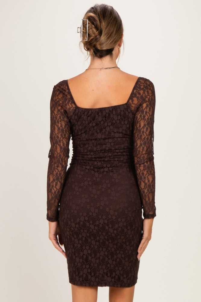 woman wearing a brown lace maternity dress with long sleeves and a fitted silhouette, showing a baby bump