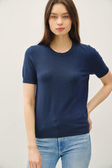 woman wearing a navy short sleeve knit top paired with light blue jeans